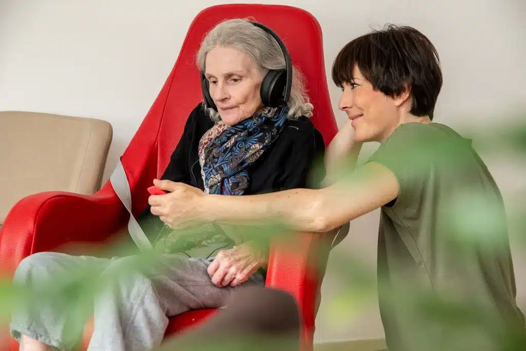 Caregiver sharing music with an older adult as part of in-home memory care