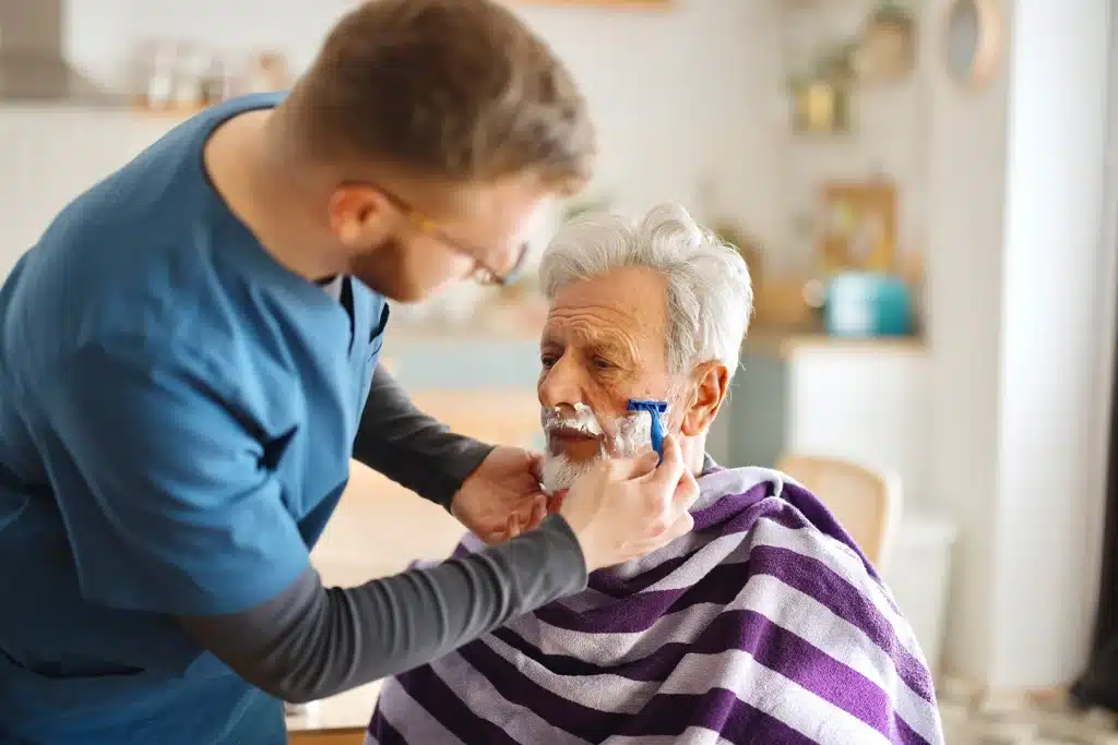 Caregiver helping an older man shave as part of dementia home care in Winnipeg