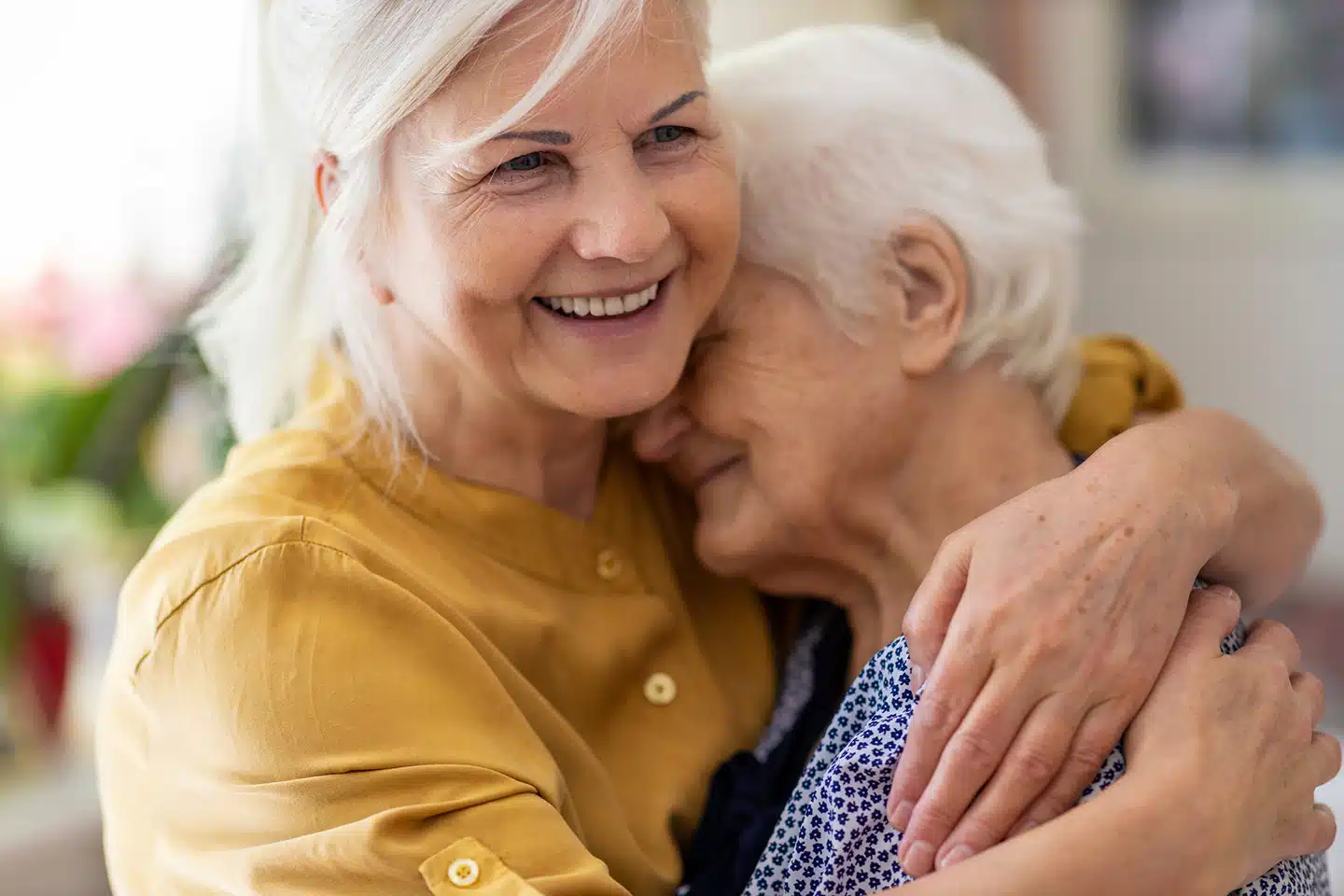 Senior women embracing while receiving caring home care assistance in Winnipeg