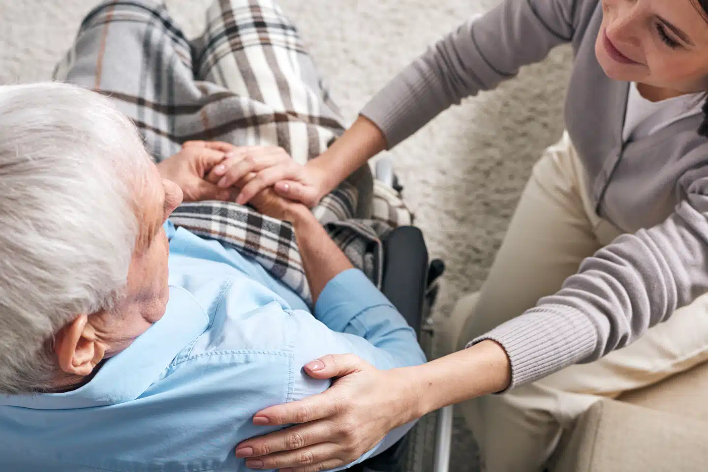 In home caregiver providing supportive home health care service to a senior in a wheelchair