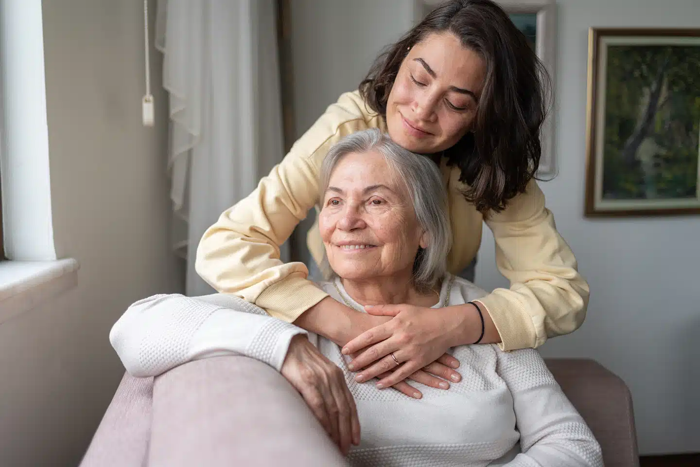 Caregiver embracing an older adult during respite support as part of palliative home care